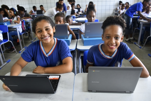 imagem de duas estudantes da Rede Estadual sentadas assistindo aula pelo Chromebook